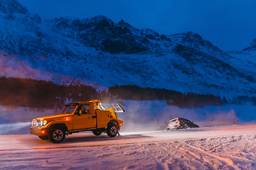 Image showing The roadside assistance service pulling the car out of the canal. An incident on a frozen Scandinavian road.