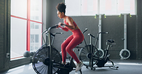 Image showing Exercise bike, cardio and girl cycling for sports fitness, athlete marathon training or high energy body workout. Gym performance motivation, wellness mindset and black woman riding bicycle machine