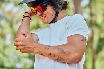 Image showing Sport, injury and man with arm pain, problem or issue while cycling in a forest on blurred background. Injured, elbow and male cyclist suffering inflammation, arthritis or joint ache during exercise