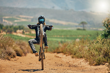 Image showing Cycling, fitness and person on a bicycle in the countryside for extreme sport, adrenaline and fun. Speed, action and cyclist on a dirt road for stunt, trick or training, freedom and balance in nature