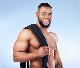 Image showing Fitness, man and portrait smile with rope for intense workout, exercise or training against blue studio background. Happy face and fit muscular male model holding thick ropes for exercising on mockup