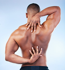 Image showing Back, strong and black man with muscle touching his spine as self love, skincare and isolated in a studio blue background. Health, wellness and strong muscular male model embracing skin