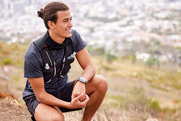 Image showing Hiking, fitness and man thinking and rest on a mountain after trekking as morning exercise, health and workout routine. Relax, break and happy young athlete or male smile on a hill in nature