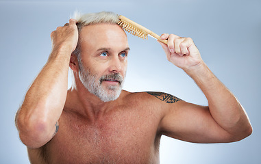 Image showing Mature man, brush hair and scalp treatment in a studio with a male model doing beauty routine. Wellness lifestyle, hairstyle care and barber and hairdresser comb with an isolated grey background