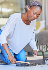 Image showing Maid, housekeeping and black woman cleaning and sweeping floor of a living room in a home or house for hygiene. Housekeeper, cleaner and domestic female remove dirt or dust with hand broom