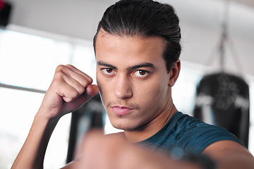 Image showing Portrait, boxer punch and man in gym ready to start workout, training or exercise. Boxing sports, wellness and face of serious male athlete throwing fist for fight, exercising or mma for strength.