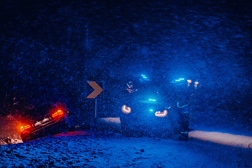 Image showing The roadside assistance service pulling the car out of the canal. An incident on a frozen Scandinavian road.