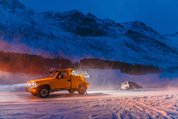 Image showing The roadside assistance service pulling the car out of the canal. An incident on a frozen Scandinavian road.