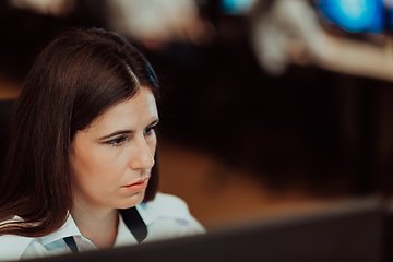 Image showing Female security operator working in a data system control room offices Technical Operator Working at workstation with multiple displays, security guard working on multiple monitors