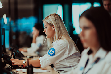 Image showing Group of Security data center operators working in a CCTV monitoring room looking on multiple monitors.Officers Monitoring Multiple Screens for Suspicious Activities