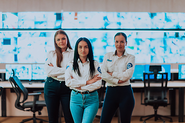 Image showing Group portrait of female security operator while working in a data system control room offices Technical Operator Working at workstation with multiple displays, security guard working on multiple