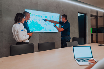 Image showing Group of security operators working in a data system control room Technical Operators Working at workstation with multiple displays, security guards working on multiple monitors in surveillan