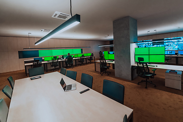 Image showing Group of Security data center operators working in a CCTV monitoring room looking on multiple monitors.Officers Monitoring Multiple Screens for Suspicious Activities