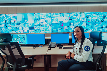 Image showing Female security operator working in a data system control room offices Technical Operator Working at workstation with multiple displays, security guard working on multiple monitors