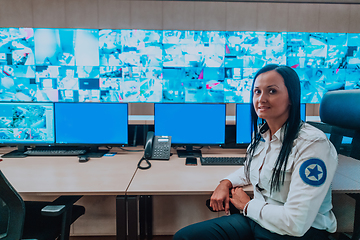 Image showing Female security operator working in a data system control room offices Technical Operator Working at workstation with multiple displays, security guard working on multiple monitors