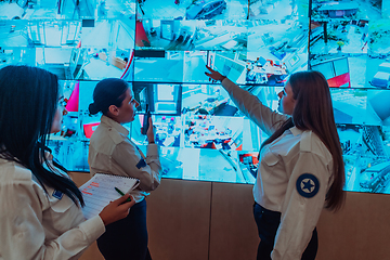 Image showing Group portrait of female security operator while working in a data system control room offices Technical Operator Working at workstation with multiple displays