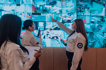 Image showing Group portrait of female security operator while working in a data system control room offices Technical Operator Working at workstation with multiple displays