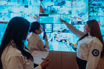 Image showing Group portrait of female security operator while working in a data system control room offices Technical Operator Working at workstation with multiple displays