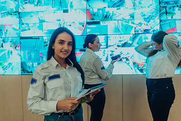 Image showing Group portrait of female security operator while working in a data system control room offices Technical Operator Working at workstation with multiple displays