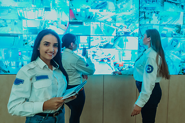 Image showing Group portrait of female security operator while working in a data system control room offices Technical Operator Working at workstation with multiple displays