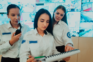 Image showing Group portrait of female security operator while working in a data system control room offices Technical Operator Working at workstation with multiple displays