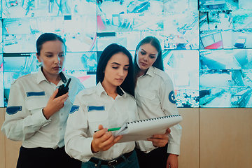 Image showing Group portrait of female security operator while working in a data system control room offices Technical Operator Working at workstation with multiple displays