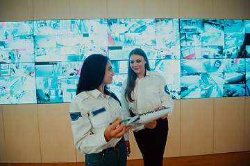 Image showing Group portrait of female security operator while working in a data system control room offices Technical Operator Working at workstation with multiple displays