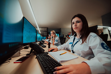 Image showing Group of Security data center operators working in a CCTV monitoring room looking on multiple monitors.Officers Monitoring Multiple Screens for Suspicious Activities