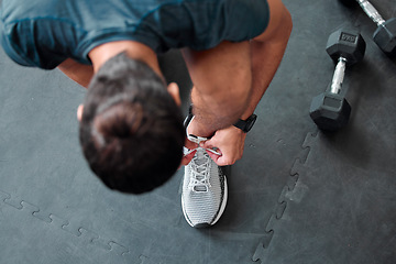 Image showing Top view, man and tie shoes in gym to start workout, training or exercise for sports. Athlete, male and tying laces on sneakers to prepare for running, cardio or exercising for health or fitness.