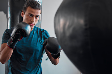 Image showing Sports, boxing and man with punching bag in gym for training, exercise or workout. Boxer, fitness athlete and serious fighter punch for fight, competition or practice, health or wellness for strength