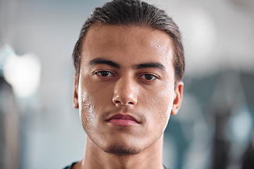 Image showing Portrait, sweat and intensity with a sports man closeup in the gym for a cardio or endurance workout. Fitness, face and focus with a male athlete taking a break after health training for wellness