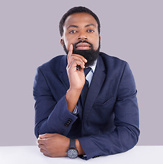 Image showing Portrait, mindset and serious with a business black man in studio on a gray background thinking about the future. Face, vision and focus with a male employee sitting at a desk, contemplating an idea