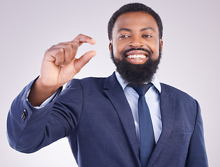 Image showing Hand gesture, size and a business black man in studio on a gray background to measure company growth. Corporate, small or tiny with a happy african american male employee showing a measurement