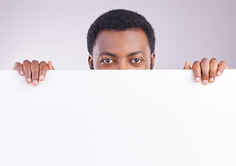 Image showing Mockup, space and portrait of a black man with a board isolated on a white background in a studio. Showing, branding and an African person peaking from a blank poster with mock up for advertisement