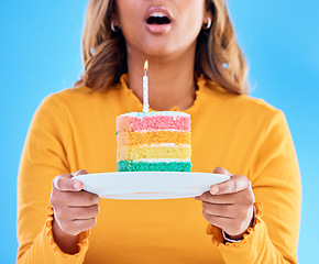 Image showing Birthday cake, celebration and blowing a candle to celebrate a gift or present isolated in a studio blue background. Dessert, sweet and woman or person excited, happiness and happy for festive