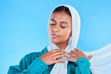 Image showing Calm woman, muslim and beauty of hijab in studio, blue background or color backdrop. Young female model, islamic culture or scarf with eyes closed, peace or religion of arabic fashion for eid mubarak