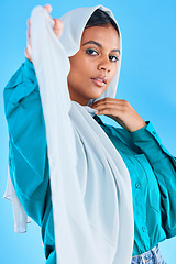 Image showing Muslim woman, beauty and portrait of hijab in studio, blue background or color backdrop. Young female model, islamic culture or scarf for religion, arabic fashion and empowerment of elegant style