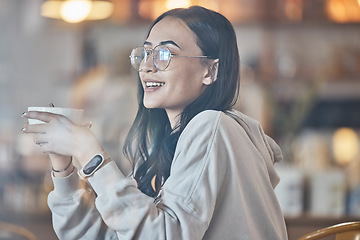 Image showing Thinking, happy and a woman drinking coffee in a cafe to relax alone over the weekend behind glass. Idea, smile and caffeine with an attractive young female enjoying a beverage in a restaurant