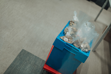 Image showing Bank employees using money counting machine while sorting and counting small iron banknotes inside bank vault. Large amounts of money in the bank