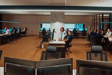 Image showing Group of Security data center operators working in a CCTV monitoring room looking on multiple monitors Officers Monitoring Multiple Screens for Suspicious Activities Team working on the System Contr