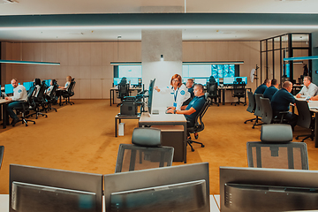 Image showing Group of Security data center operators working in a CCTV monitoring room looking on multiple monitors Officers Monitoring Multiple Screens for Suspicious Activities Team working on the System Contr