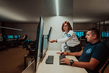 Image showing Group of Security data center operators working in a CCTV monitoring room looking on multiple monitors Officers Monitoring Multiple Screens for Suspicious Activities Team working on the System Contr