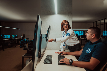 Image showing Group of Security data center operators working in a CCTV monitoring room looking on multiple monitors Officers Monitoring Multiple Screens for Suspicious Activities Team working on the System Contr