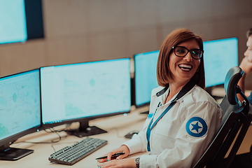 Image showing Female security operator working in a data system control room offices Technical Operator Working at workstation with multiple displays, security guard working on multiple monitors