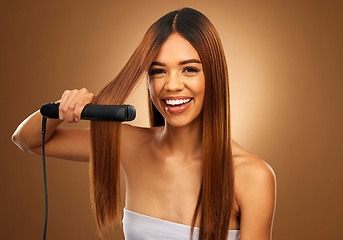 Image showing Hair care, portrait of woman with flat iron, smile and beauty for luxury salon treatment tool on brown background. Beauty, electric straightener and happy model with straight hairstyle in studio.