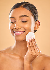 Image showing Skin, beauty and face cotton of woman in studio for cosmetics, dermatology or makeup. Aesthetic female .hand with product for self care, remove makeup and natural facial results on a brown background