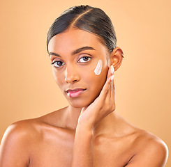 Image showing Face portrait, skincare and woman with cream in studio isolated on a brown background. Dermatology, cosmetics or confident Indian female model with lotion, beauty creme or moisturizer for skin health