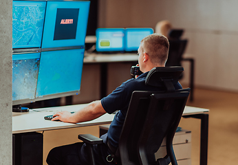 Image showing Group of Security data center operators working in a CCTV monitoring room looking on multiple monitors.Officers Monitoring Multiple Screens for Suspicious Activities