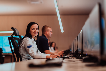 Image showing Group of Security data center operators working in a CCTV monitoring room looking on multiple monitors.Officers Monitoring Multiple Screens for Suspicious Activities