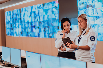 Image showing Group portrait of female security operator while working in a data system control room offices Technical Operator Working at workstation with multiple displays